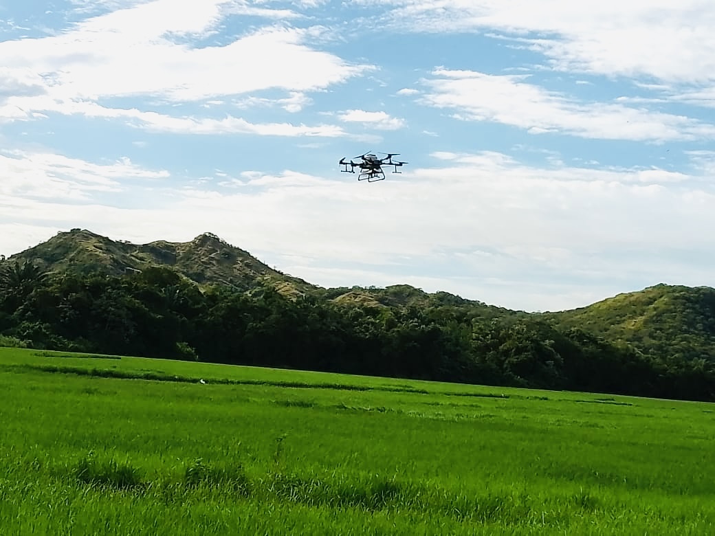 Drone AgroSky en misión sobre campo verde con montañas